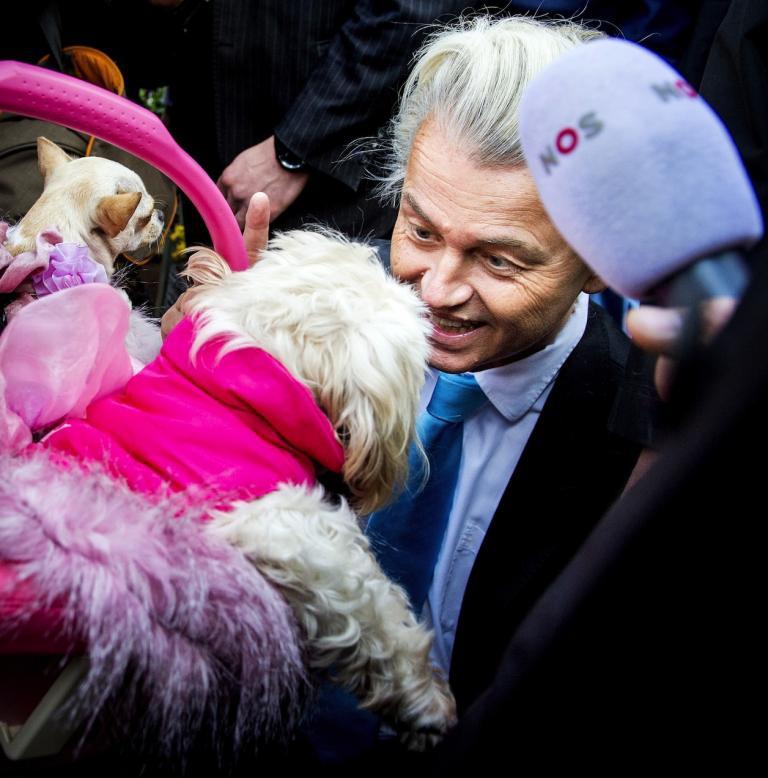 In this 2014 photo, Geert Wilders greets a little dog at a market in The Hague during campaigning.
