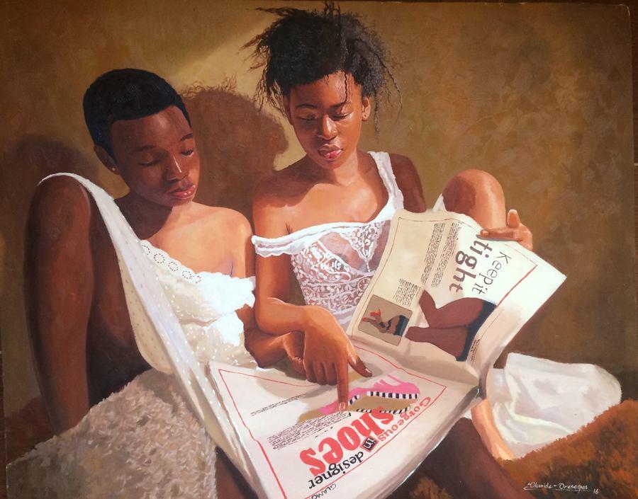 Two girls reading a newspaper.