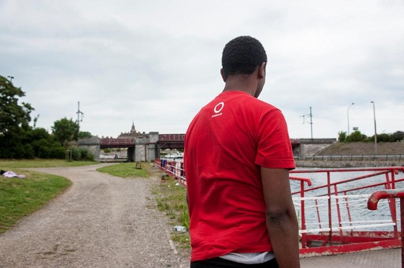 Hussen, a 20-year-old Oromo refugee, stands in front of the canal in Calais where he fell during a police check, July 26, 2017. 