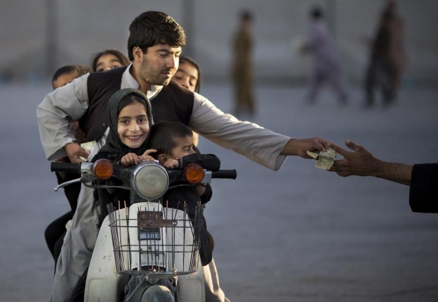 An Afghan man with his five children on his motorbike pays to enter a park in Kandahar, Afghanistan, on Nov. 1, 2013.