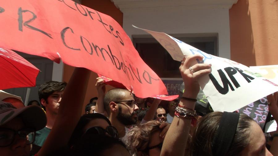 Students hold signs against budget cuts to the University of Puerto Rico durng a protest on May 13