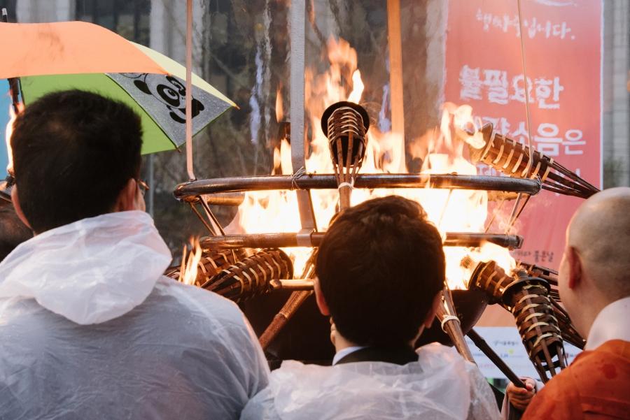 Buddhist monks and political officials lit torches at a public event for reciting the Diamond Sutra in downtown Seoul on April 5, 2017.  