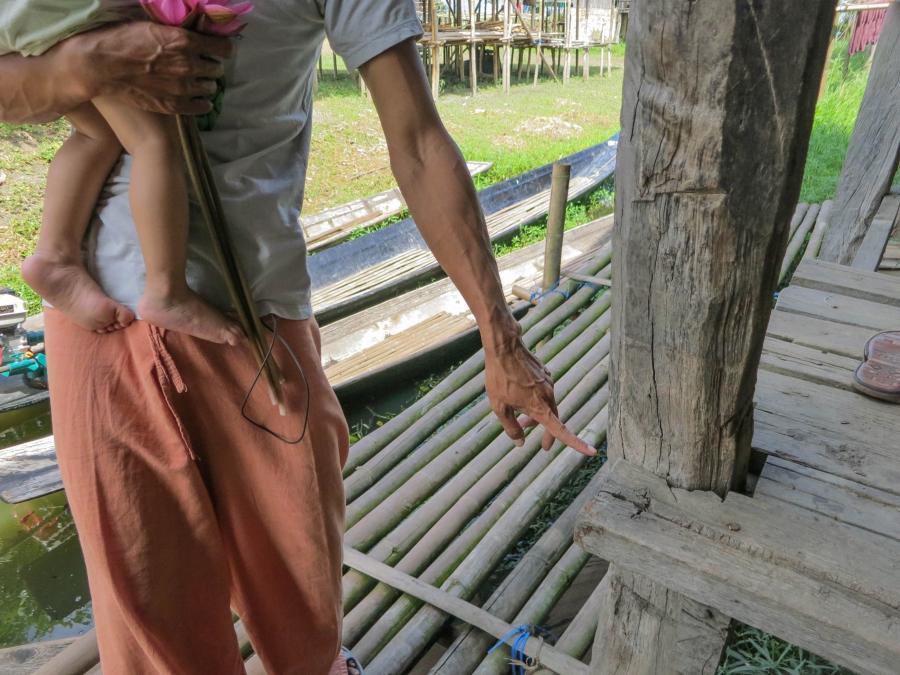 Activist Kyaw Soe points to the level on his house which Inle Lake's water used to regularly reach. Like most here, the house was built on stilts and used to stand above open water most of the year. Now, he says, it's on dry land most of the year.