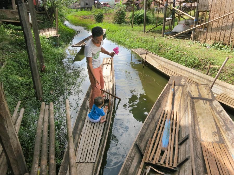 Kyaw Soe and his son Lone Lone play at paddling in a canoe outside their home on the edge of Inle Lake.