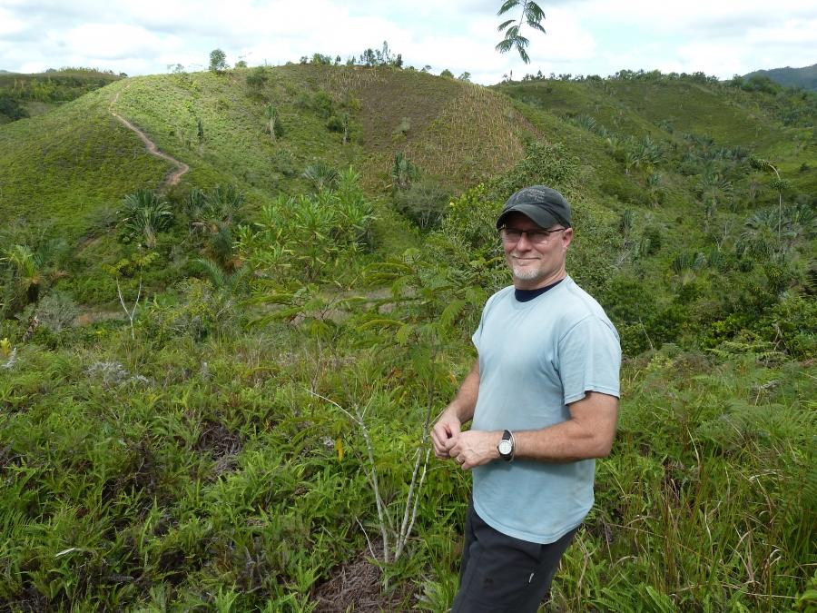 Madagascar Biodiversity Partnership director Ed Louis stands near a hillside recently replanted with new seedlings. The reforestation project depends on seeds eaten and pooped out by lemurs.