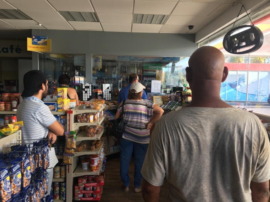 A line of people waiting in a gas station in San Juan, Puerto Rico.