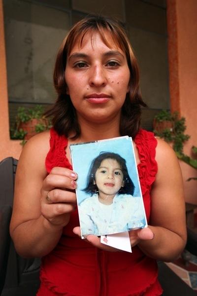 Loyda Rodríguez holding a photograph that shows her daughter Anyelí.