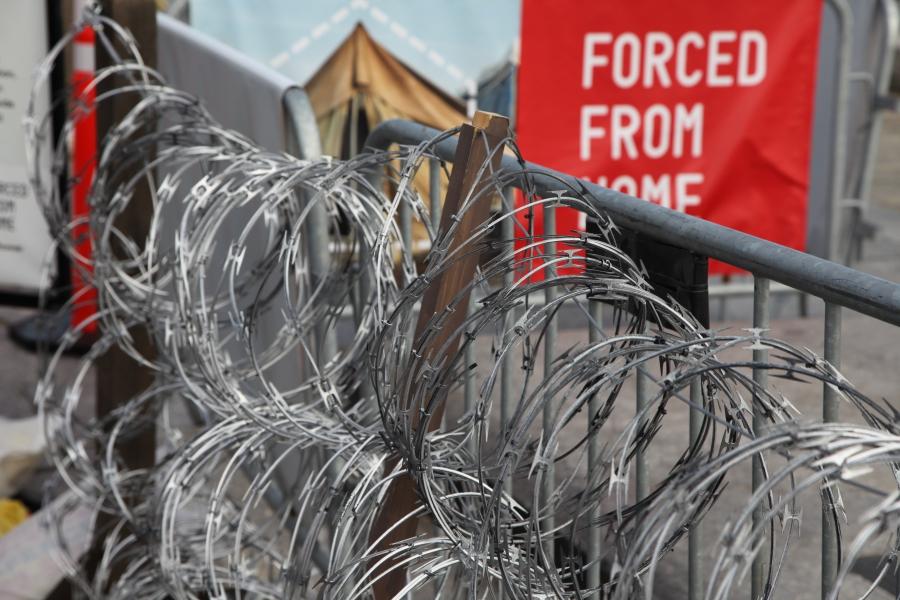 A simulated border is marked by a fence and razor wire.