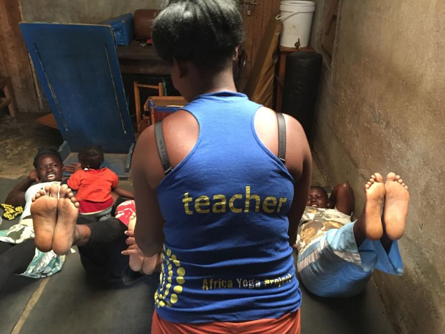Joyce Wanjiku assists first time yoga students in the Nairobi slum of Kariobangi.