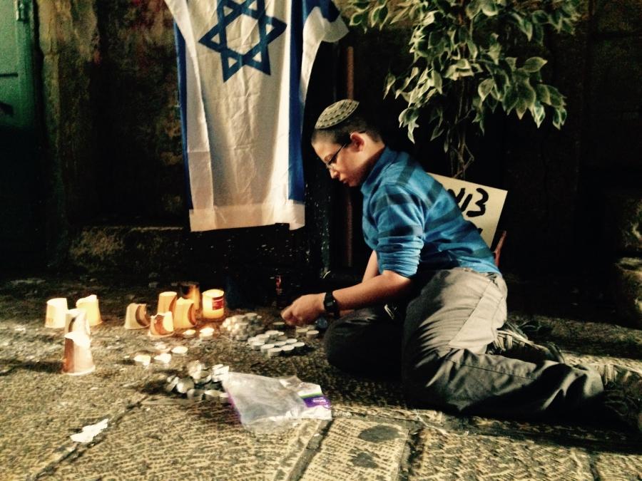 Israeli kid lights candles for Israeli stabbing victims.