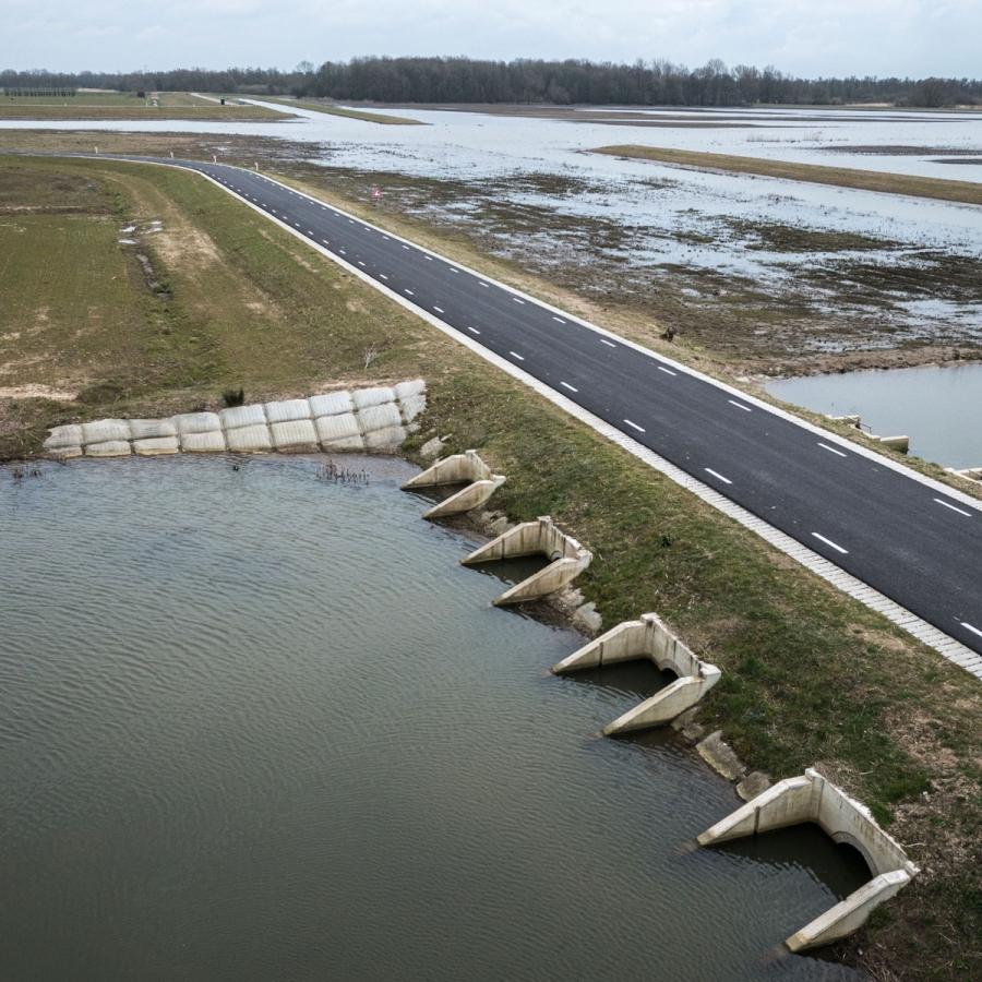 A new dike reopens some of the historic floodplain of the Rhine River (R) near Nijmegen, the Netherlands from still-protected land (L).