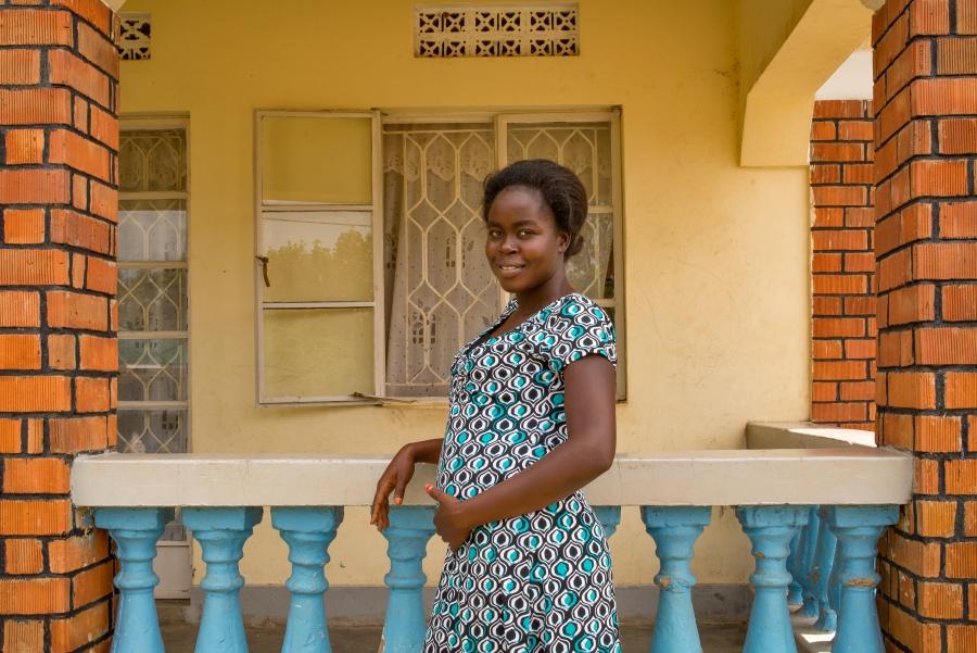 Jacqueline, 24, poses for a photo outside her home in Arua, Uganda.