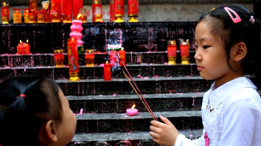 Children light candles at one of China's many Buddhist temples.