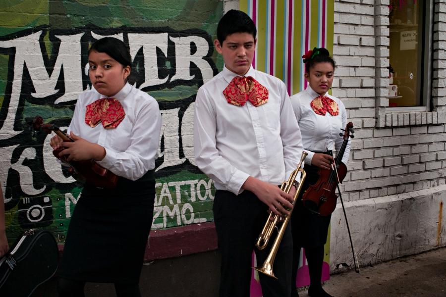 Young people in mariachi clothes with instruments