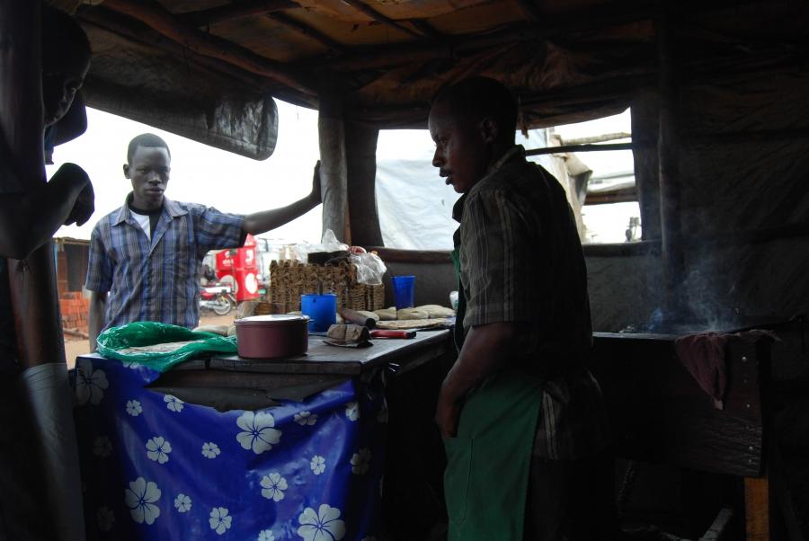 A man sells chapati bread mixed with beans and other local dishes near Bidi Bidi's main entrance area.