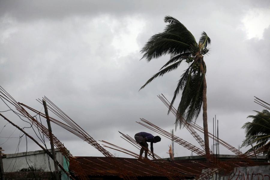A man fixes a roof of a partially built house after Hurricane Matthew in Les Cayes, Haiti.