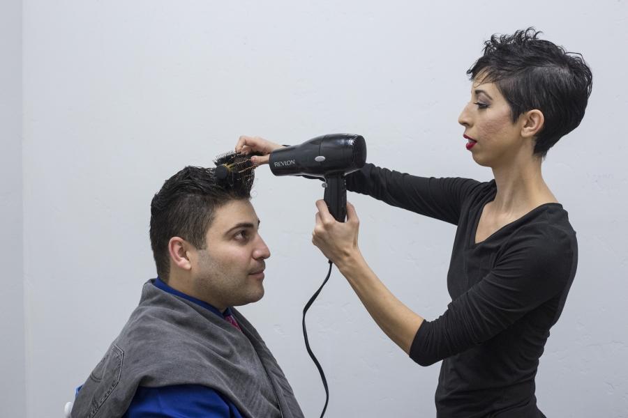 Omar’s wife, Jasmín, helps him fix his hair before their performance