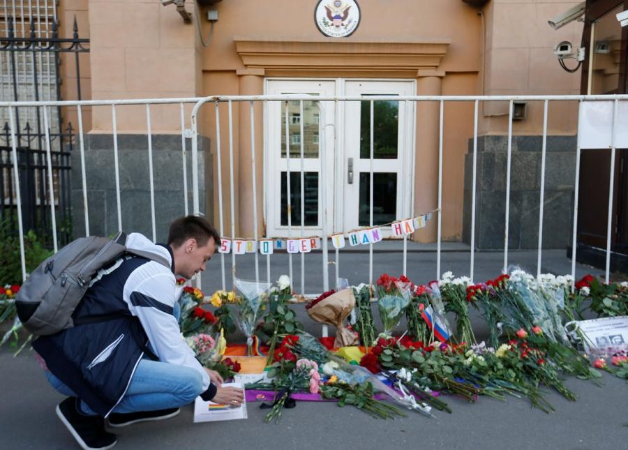 A man places a candle for the victims of the Orlando shooting in front of the US Embassy in Moscow, Russia.