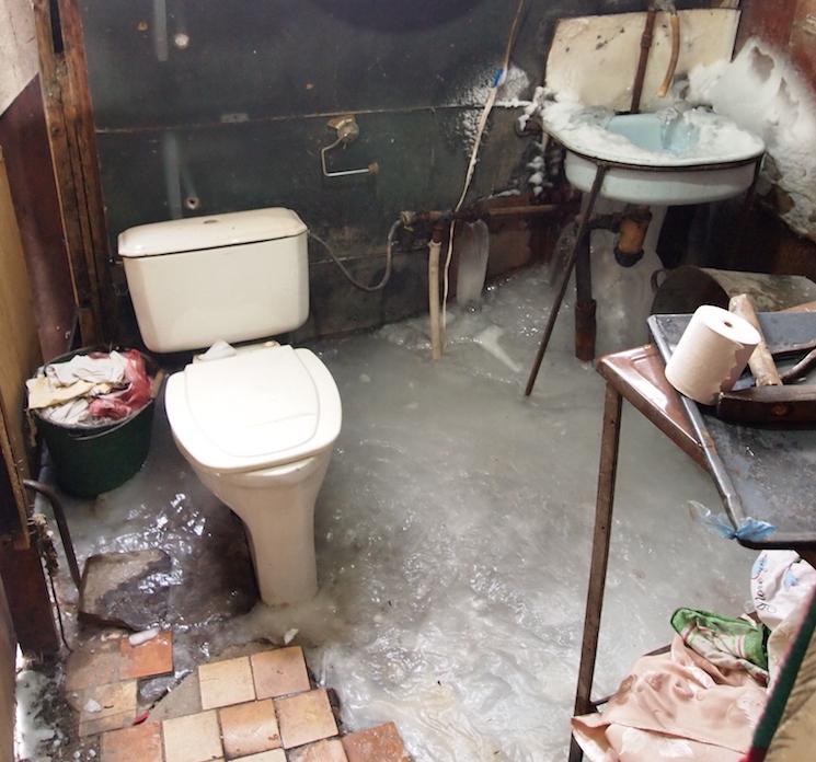 Winters in the container homes are especially tough: notice the solid ice on the floor and sink.