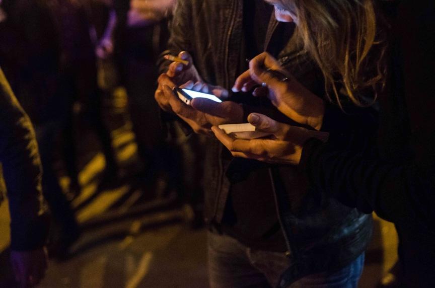 Bystanders and victims write down phone numbers to make calls near the Bataclan concert hall in Paris on Friday night.