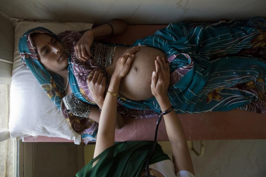 Suman, a 25-year-old pregnant woman, lies on an examination table as a nurse places her examines her during a check up at a community health centre in the remote village of Chharchh, in Madhya Pradesh, February 24, 2012.
