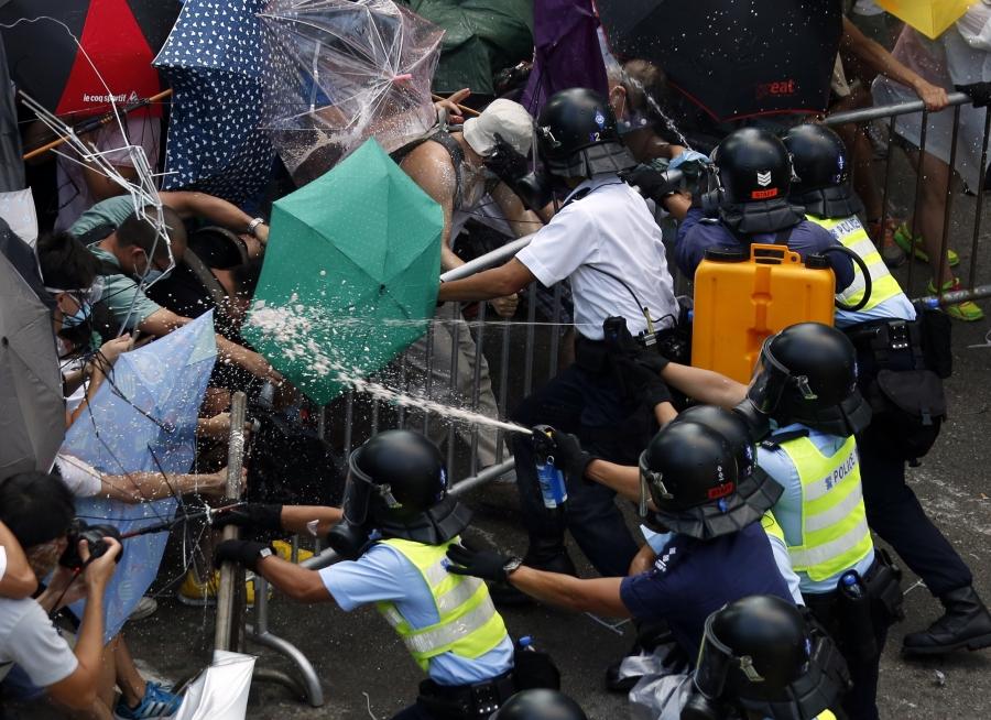 Police use pepper spray as they clash with protesters jamming the main street to the central financial district outside government headquarters in Hong Kong on September 28, 2014.