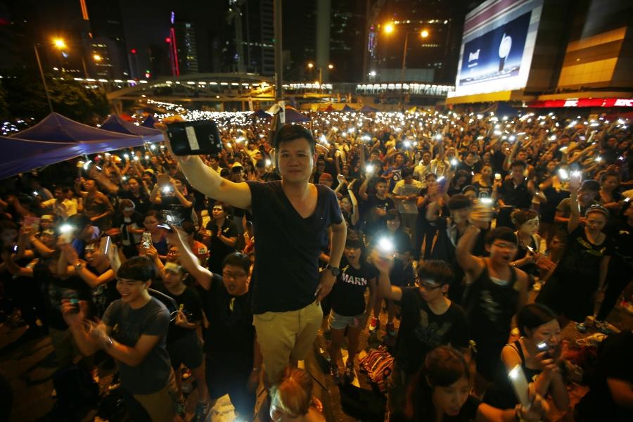 Hong Kong protesters turn on their mobile phone flashlights as they block an area outside government headquarters.