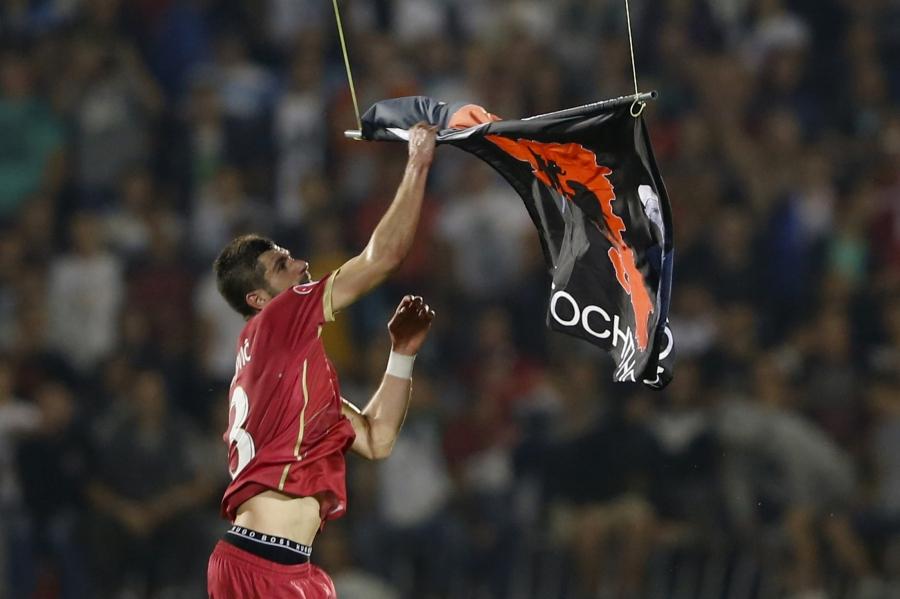 Stefan Mitrovic of Serbia grabs a flag depicting so-called Greater Albania, that was flown over the pitch during the Euro 2016 qualifying soccer match between Serbia and Albania at the FK Partizan stadium in Belgrade October 14, 2014.