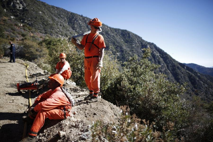 Prison inmates lay water pipe on a work project outside Oak Glen Conservation Fire Camp #35 in Yucaipa, California November 6, 2014. 