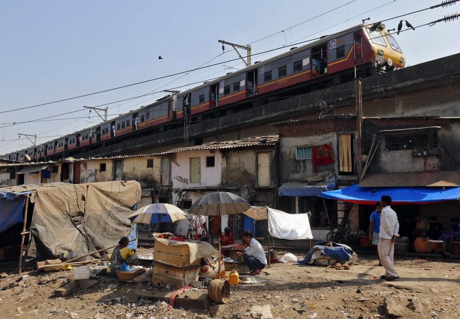 A suburban train passes through a slum area over a bridge in Mumbai February 26, 2015.