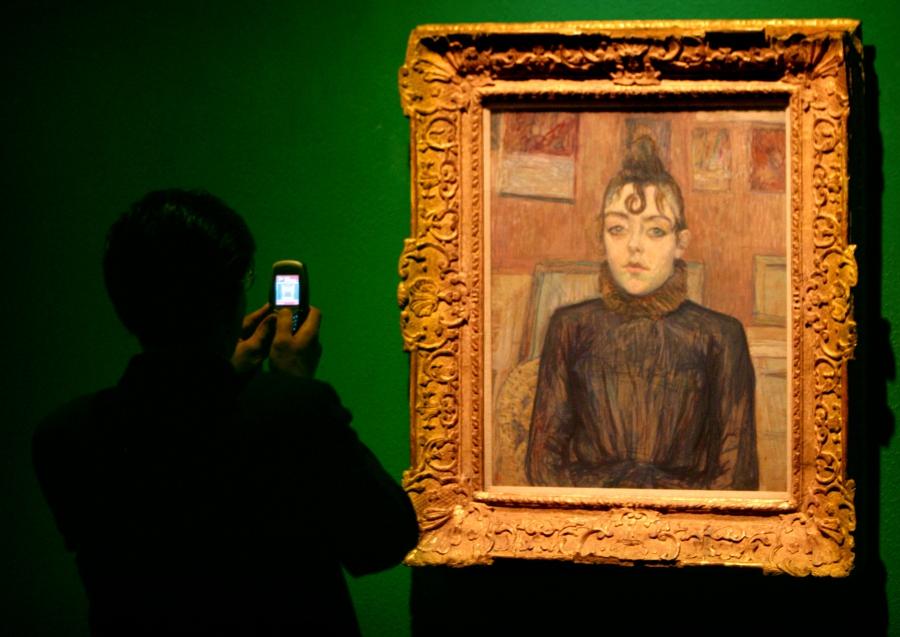 An Iranian man takes a picture of a painting by 19th century painter Henri de Toulouse-Lautrec during the Modern Art Movement exhibition at Tehran Museum of Contemporary Art in Tehran August 29, 2005.