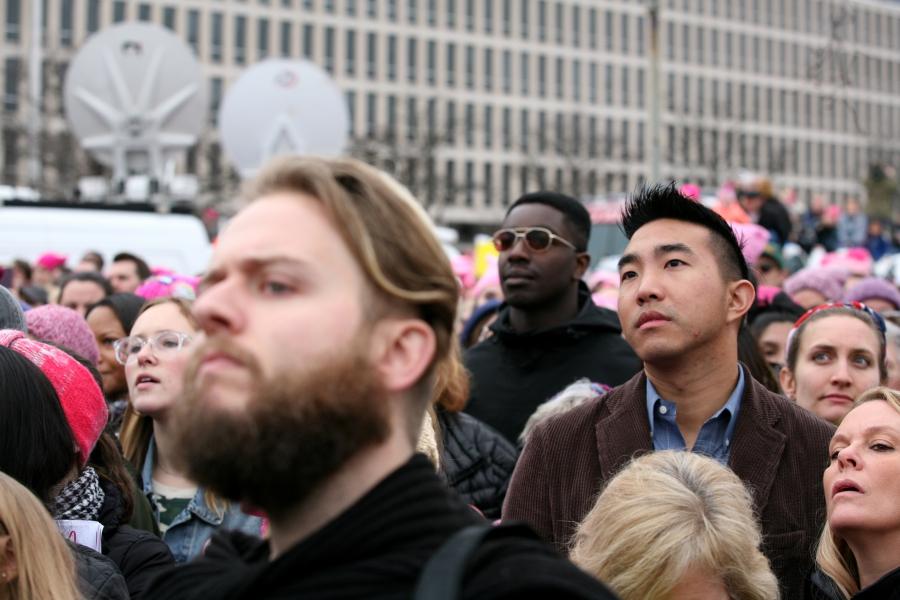 People listen to speeches at the Women's March, held in opposition to the agenda and rhetoric of President Donald Trump in Washington, DC, January 21, 2017.