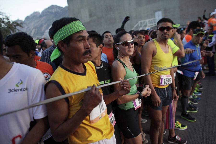 A Tarahumara man (front L) prepares next to other athletes before competing in a 21 km (13 miles) marathon in San Pedro Garza Garcia, on the outskirts of Monterrey, February 16, 2014. 