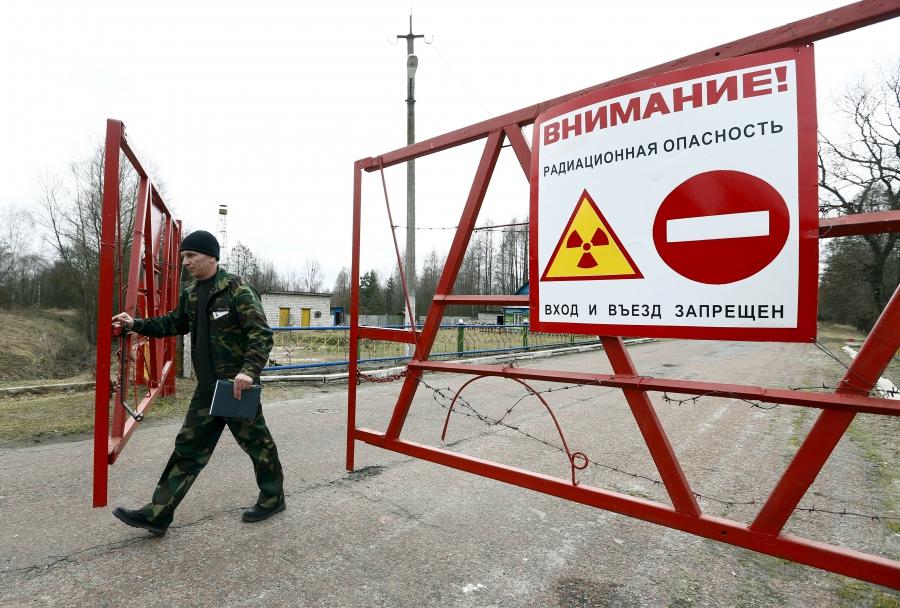 An employee opens the gate at a checkpoint in the exclusion zone around the Chernobyl nuclear reactor. After the April 26, 1986 accident, roughly 350,000 people were relocated from the zone.