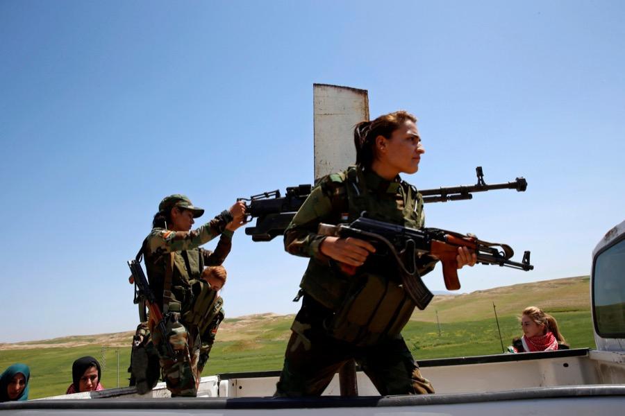 Yazidi female fighter Asema Dahir, 21, holds a weapon as she rides a pickup truck during a deployment near the front line of the fight against ISIS militants in Nawaran, near Mosul, Iraq, on April 20.