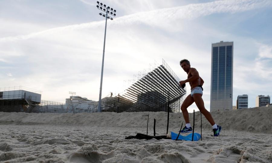A man runs near a mutilated body part near the construction site of the beach volleyball venue for the 2016 Rio Olympics on Copacabana beach, on June 29.
