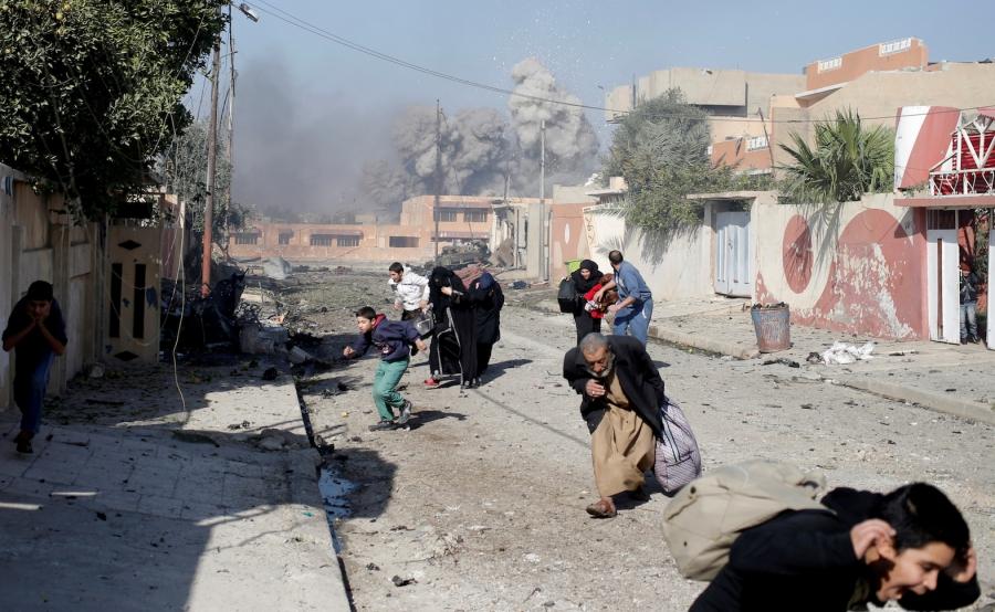 People run in panic after a coalition airstrike hit ISIS positions in the Tahrir neighborhood of Mosul, Iraq