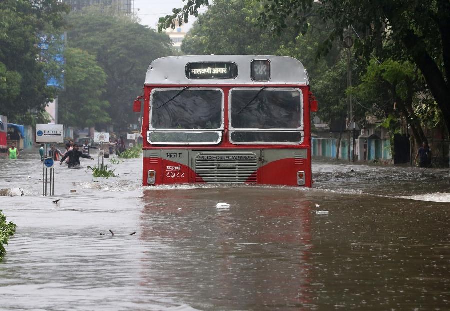 A passenger bus moves through a water-logged road during rains in Mumbai.