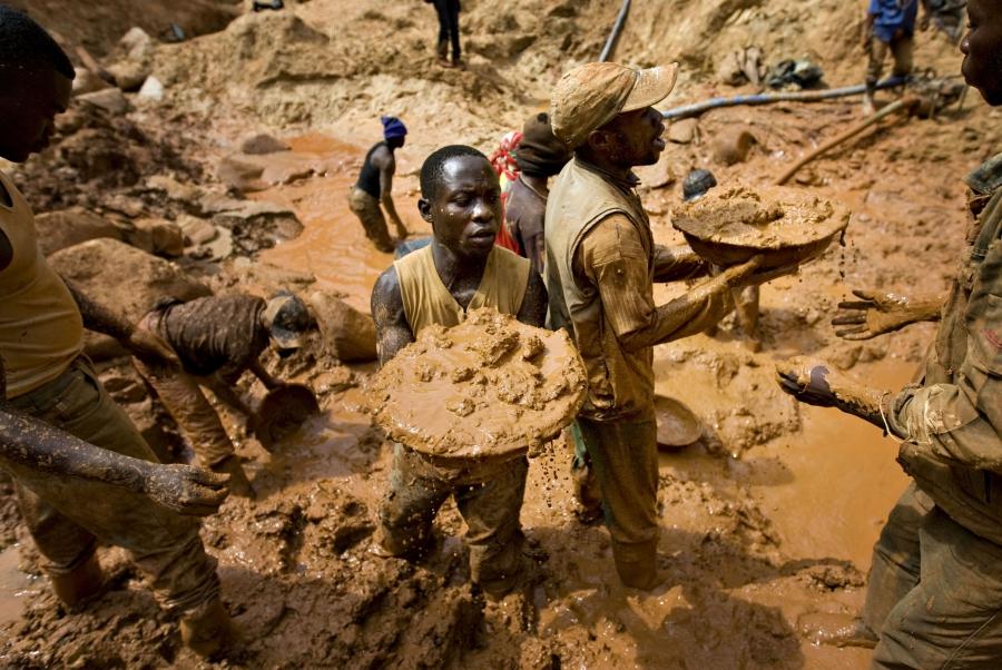 Gold miners form a human chain while digging an open pit at the Chudja mine near the village of Kobu, in northeastern DRC, Feb. 23, 2009. 