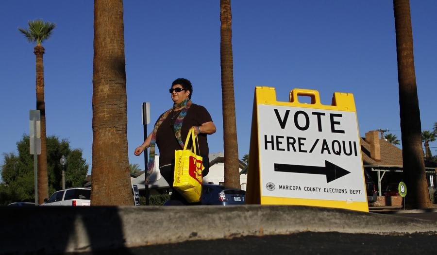 Woman walks past voter sign