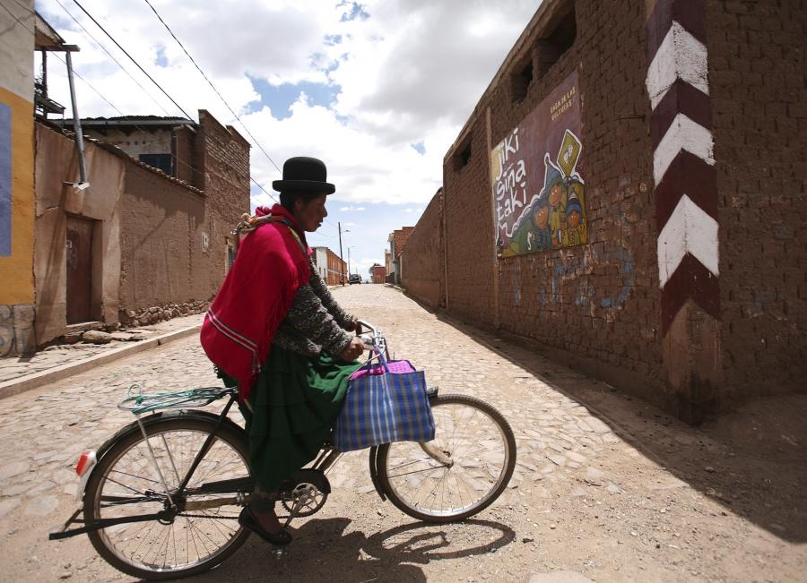An Aymara woman rides her bicycle in Tiwanaku, a UNESCO world heritage site about 40 miles west of La Paz near the shores of Lake Titicaca, 2012. 