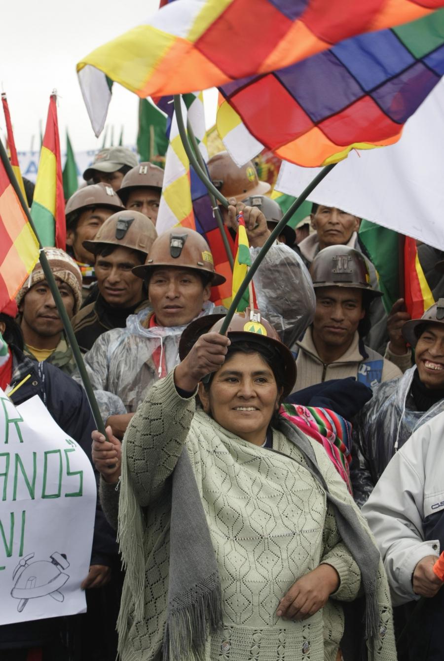 A Bolivian woman waves the Wiphala, the flag of native Andeans, while awaiting the arrival of President Evo Morales to enact the new constitution in a public gathering of thousands of his supporters, in El Alto on the outskirts of La Paz, February 7, 2009