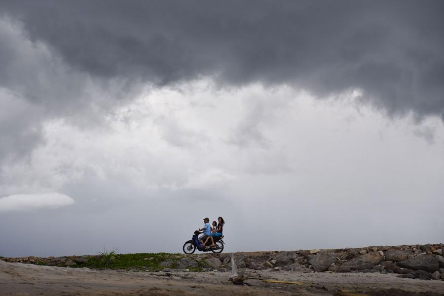 A man, child and woman ride a motor bike near the beaches of Pulau Weh island, Indonesia.
