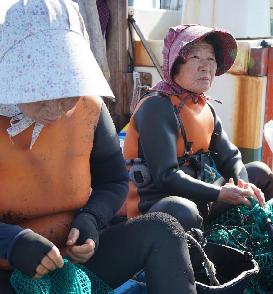 After the dive, the haeynyos swap their dive masks for floral sunhats.