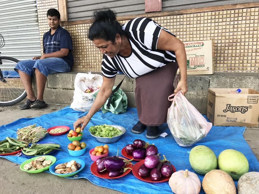 Sunila Wati sets her produce out on a tarp on the sidewalk hoping for customers