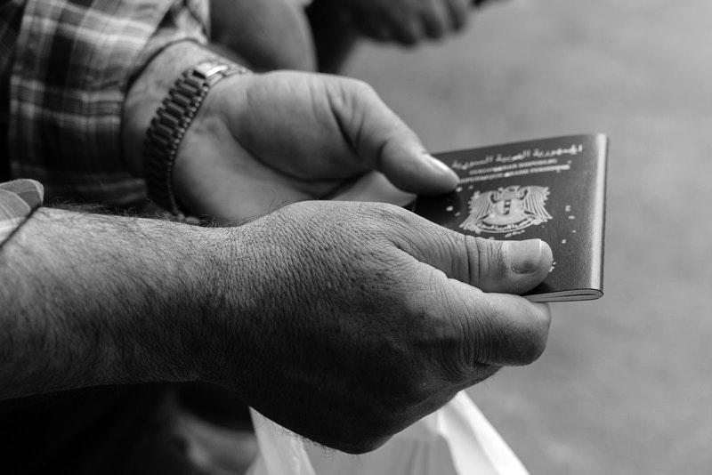 A Syrian man holds his passport outside the Syrian consulate in Istanbul on May 4, 2017