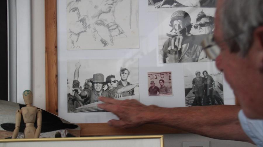 Topol pointing to a photo of himself serving in the Israeli army during the 1967 Mideast war.