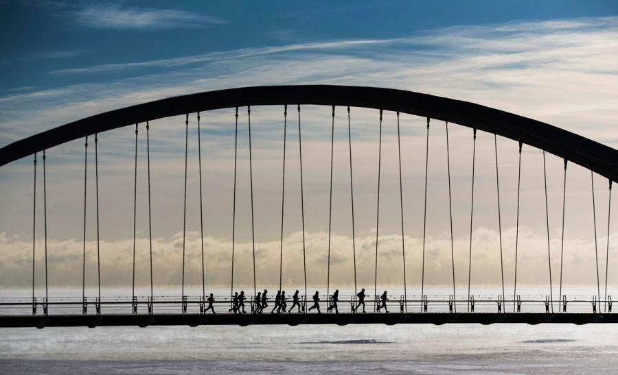 A group of joggers run across the Humber Bay Arch Bridge during extreme cold temperatures in Toronto.
