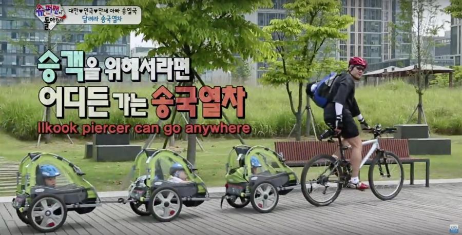 Actor Song Il Kook takes his triplet boys out for a ride around the neighborhood in their bike trailers.