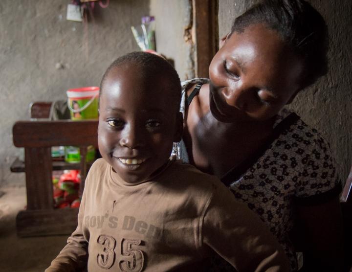 Nine-year old Steven Mafabi sits on his mother's lap. He was treated for hydrocephalus as an infant at the CURE Children's Hospital in Mbale, Uganda.